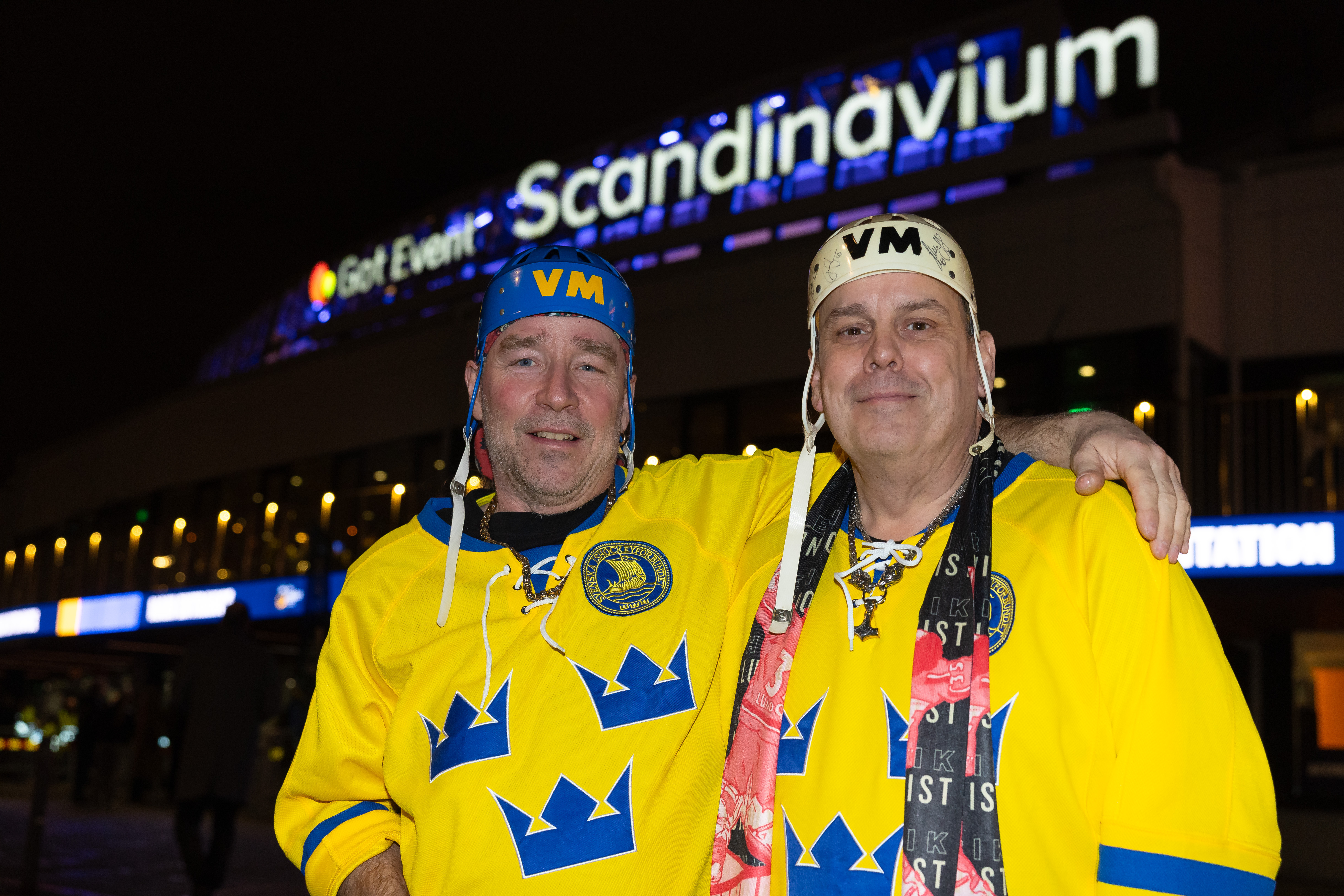 Glada supportrar poserar framfor kameran